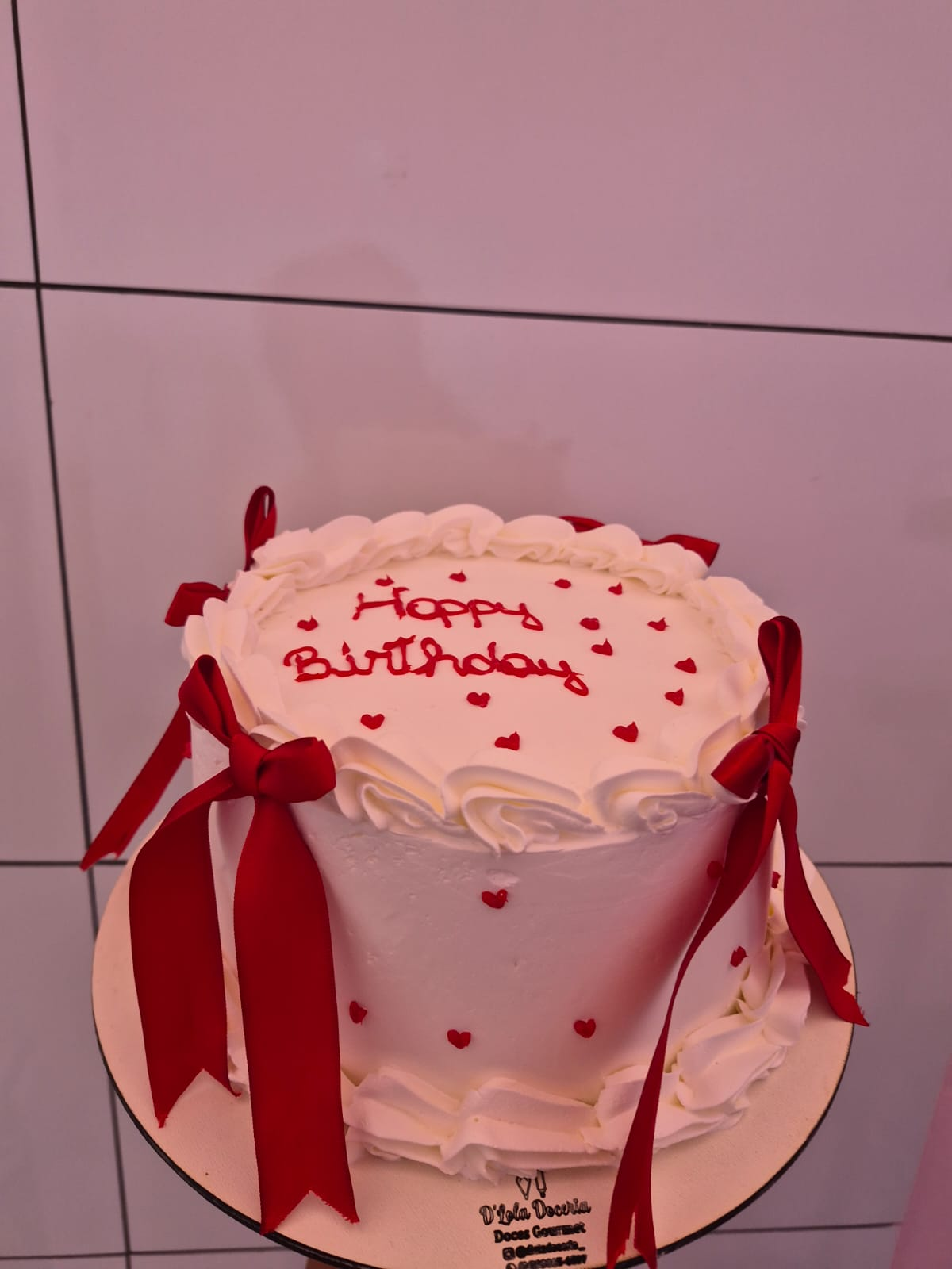 Bolo branco Happy Birthday com laços vermelhos